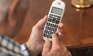 Senior mit schnurlosem Telefon